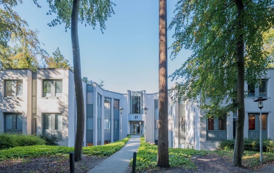 Het kantoor aan de Mozartlaan 27 in Hilversum, tussen de bomen, met het huisnummer boven de entree